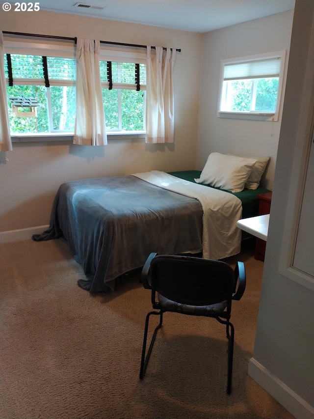 carpeted bedroom with visible vents and baseboards