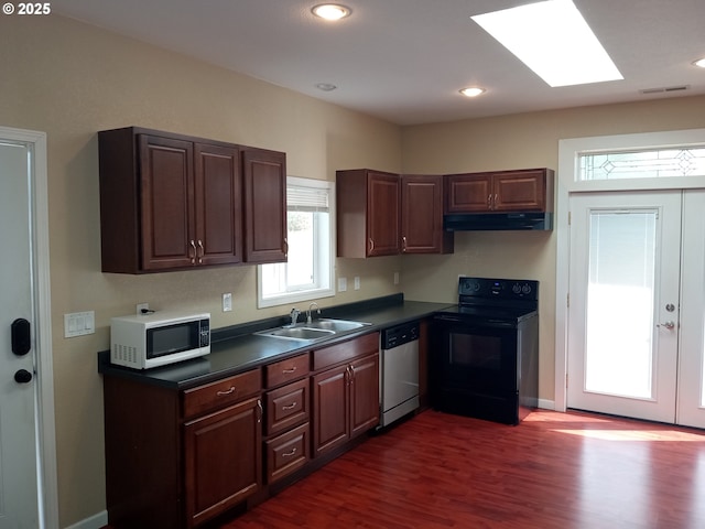 kitchen featuring a sink, under cabinet range hood, stainless steel dishwasher, black / electric stove, and white microwave