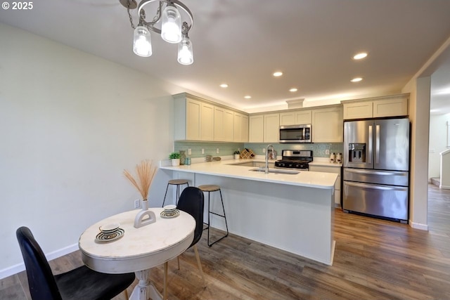 27 NW 6th Pl, Warrenton, OR 97146 - kitchen with backsplash, light countertops, stainless steel appliances, and a peninsula