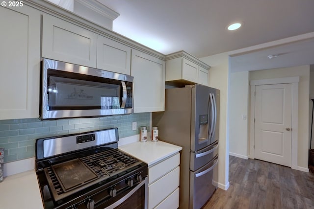 27 NW 6th Pl, Warrenton, OR 97146 - kitchen featuring backsplash, wood finished floors, stainless steel appliances, and light countertops