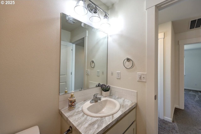 27 NW 6th Pl, Warrenton, OR 97146 - half bathroom with baseboards, visible vents, vanity, and toilet