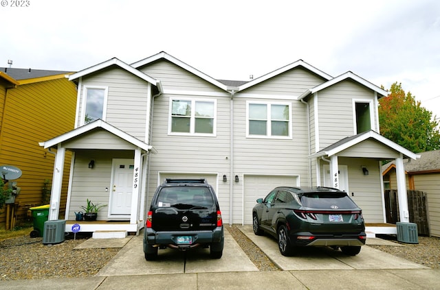 view of front facade with a garage, central air condition unit, and concrete driveway