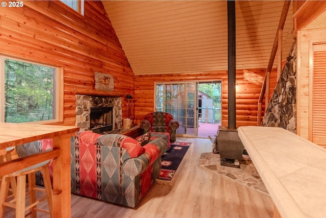 177 Northwoods, Cougar, WA 98616 - living room featuring log walls, wood finished floors, high vaulted ceiling, plenty of natural light, and a wood stove