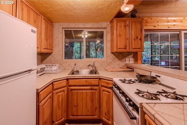 177 Northwoods, Cougar, WA 98616 - kitchen featuring white appliances, a sink, decorative backsplash, tile countertops, and a textured ceiling