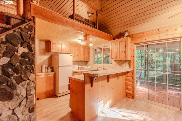 177 Northwoods, Cougar, WA 98616 - kitchen with light brown cabinets, white appliances, vaulted ceiling, light wood-type flooring, and tile countertops