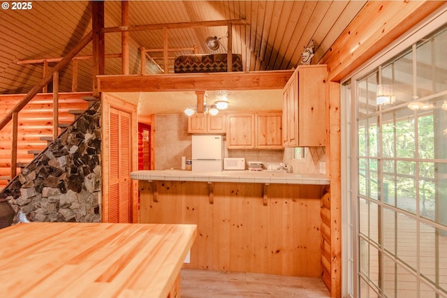 177 Northwoods, Cougar, WA 98616 - kitchen featuring white appliances, tile countertops, light brown cabinetry, light wood-type flooring, and lofted ceiling