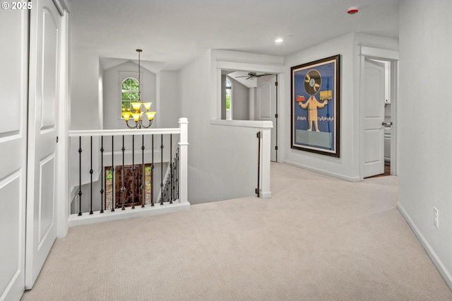 hall with an upstairs landing, carpet flooring, a chandelier, healthy amount of natural light, and recessed lighting