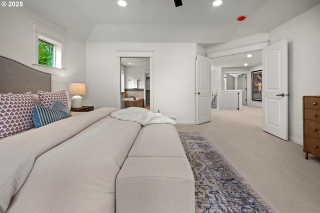 bedroom featuring light colored carpet, baseboards, recessed lighting, lofted ceiling, and ensuite bath