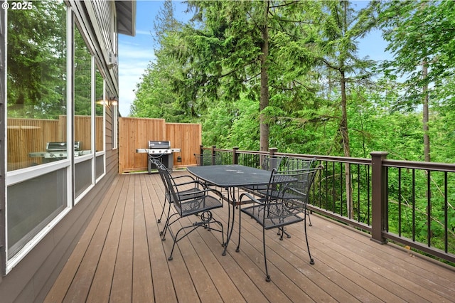 wooden deck with grilling area and outdoor dining area