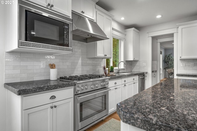kitchen with high end range, black microwave, under cabinet range hood, white cabinets, and recessed lighting