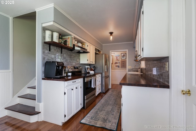 520 NE 5th St, Clatskanie, OR 97016 - kitchen featuring appliances with stainless steel finishes, dark countertops, dark wood-style flooring, tasteful backsplash, and white cabinets