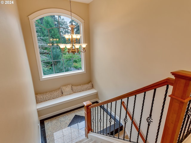 staircase featuring a healthy amount of sunlight and a notable chandelier