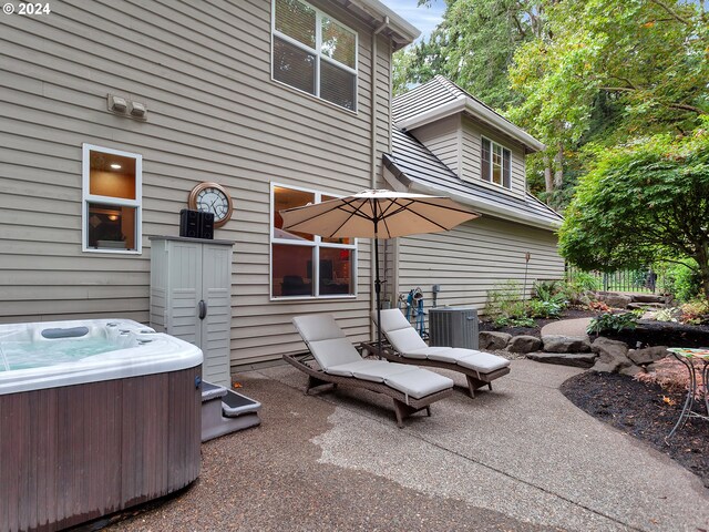 view of patio with central AC and a hot tub