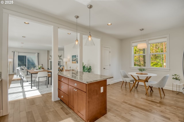 kitchen with brown cabinetry, plenty of natural light, and light wood-style flooring