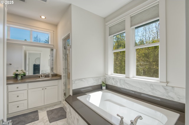 full bath featuring vanity, a garden tub, a healthy amount of sunlight, and a shower stall