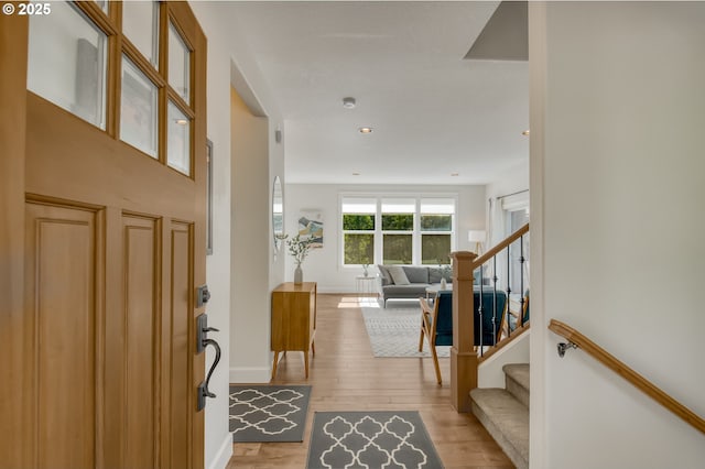 entryway with stairway, baseboards, recessed lighting, and light wood finished floors