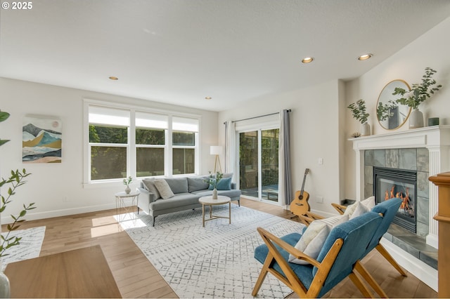 living area featuring recessed lighting, baseboards, wood finished floors, and a fireplace