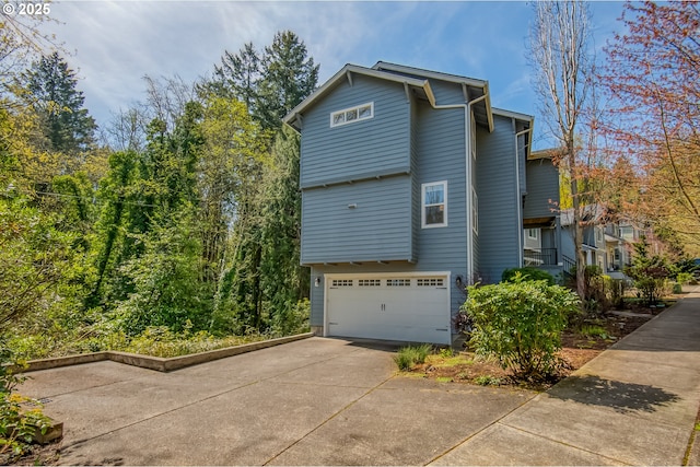 view of home's exterior with concrete driveway and an attached garage