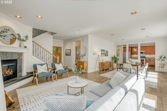living room with stairs, recessed lighting, baseboards, and a fireplace