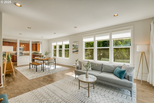 living room featuring recessed lighting, baseboards, and light wood-style floors