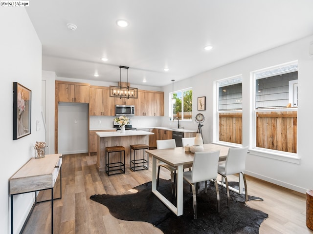 dining room with baseboards, light wood finished floors, and recessed lighting