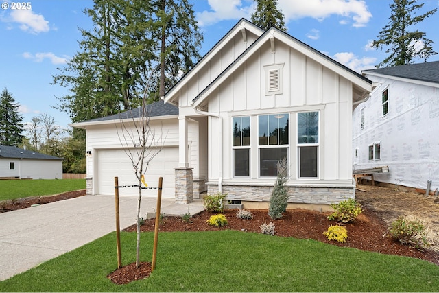 modern inspired farmhouse featuring driveway, an attached garage, a front lawn, stone siding, and board and batten siding