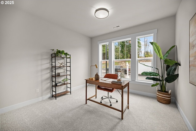 carpeted office featuring visible vents and baseboards