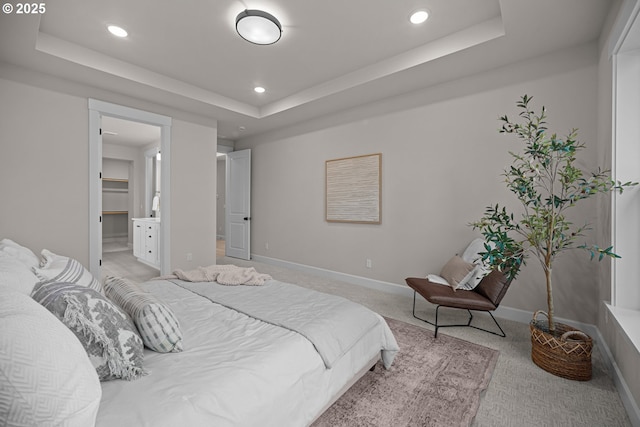 bedroom featuring a tray ceiling, recessed lighting, baseboards, and light carpet