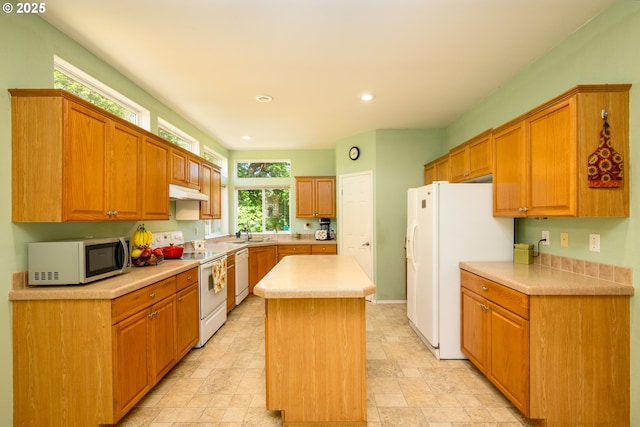 982 Reston Rd, Roseburg, OR 97471 - kitchen with white appliances, under cabinet range hood, light countertops, recessed lighting, and a kitchen island