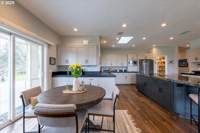 33685 Van Duyn Rd, Eugene, OR 97408 - kitchen with appliances with stainless steel finishes, dark wood-style flooring, a skylight, a sink, and recessed lighting
