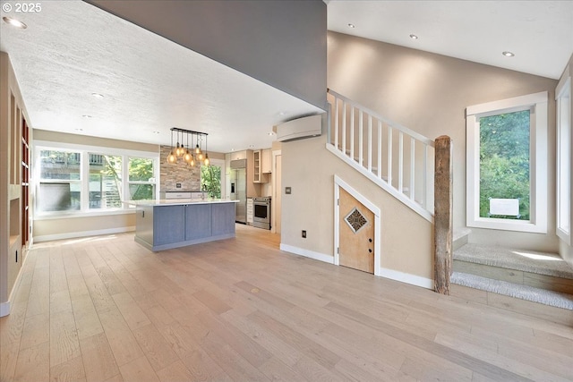 7752 SW Barnes Rd Unit B, Portland, OR 97225 - unfurnished living room featuring light wood-style flooring, stairs, baseboards, recessed lighting, and a chandelier