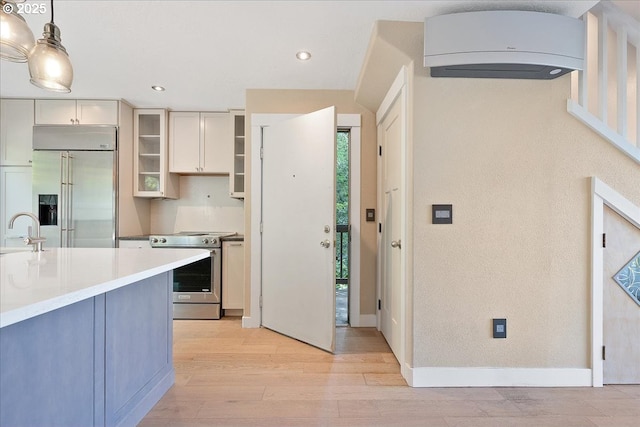 7752 SW Barnes Rd Unit B, Portland, OR 97225 - kitchen featuring stainless steel appliances, a sink, glass insert cabinets, light wood-type flooring, and light countertops