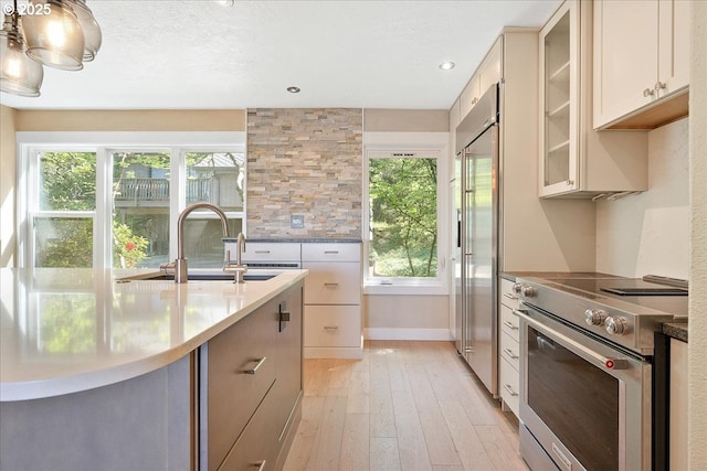 7752 SW Barnes Rd Unit B, Portland, OR 97225 - kitchen featuring high end appliances, a sink, healthy amount of natural light, light wood-type flooring, and recessed lighting