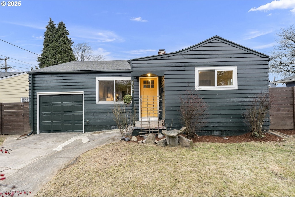 view of front of property with a garage and a front lawn