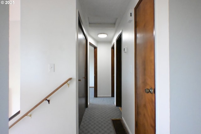 hallway featuring carpet flooring and baseboards