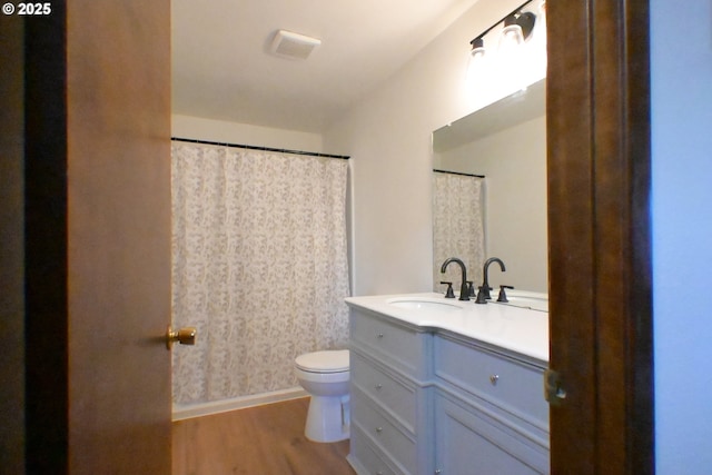 bathroom with wood finished floors, vanity, and toilet