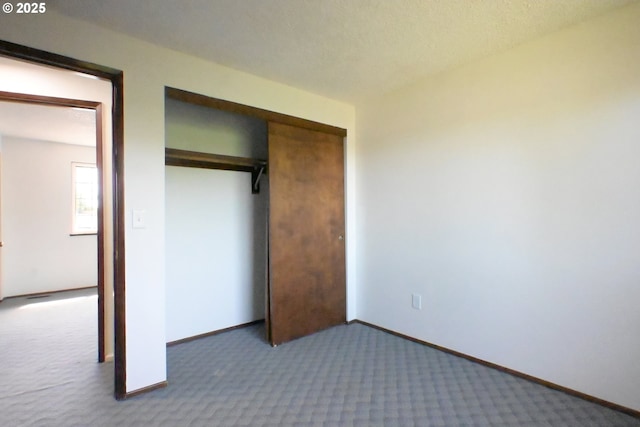 unfurnished bedroom with carpet flooring, a closet, and baseboards