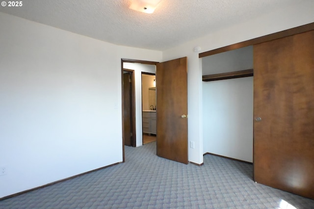 unfurnished bedroom with carpet floors, baseboards, a closet, and a textured ceiling