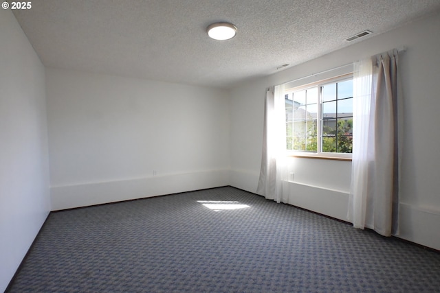 carpeted spare room with a textured ceiling and baseboards