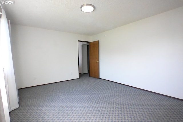 carpeted empty room with baseboards