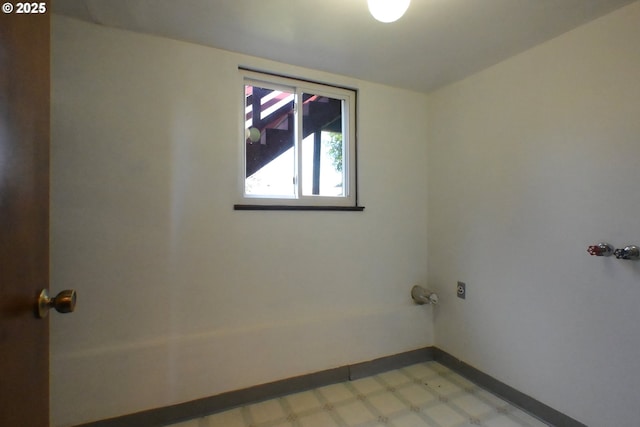 laundry area with light floors and baseboards