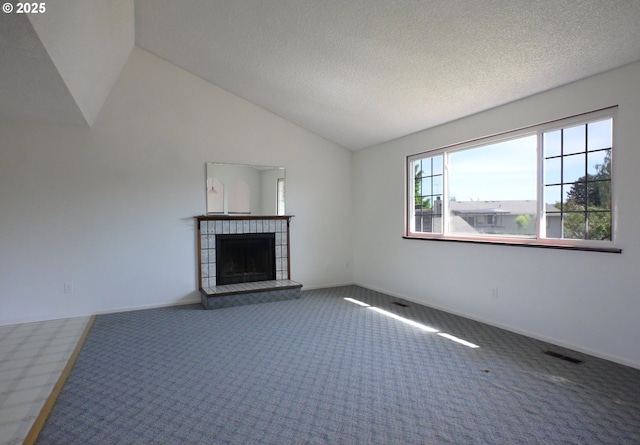 unfurnished living room featuring carpet, lofted ceiling, a fireplace, a textured ceiling, and baseboards