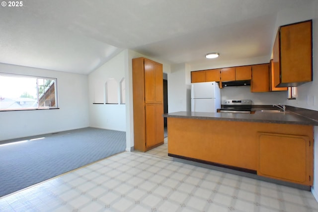 kitchen with freestanding refrigerator, stainless steel electric stove, a peninsula, a sink, and brown cabinetry