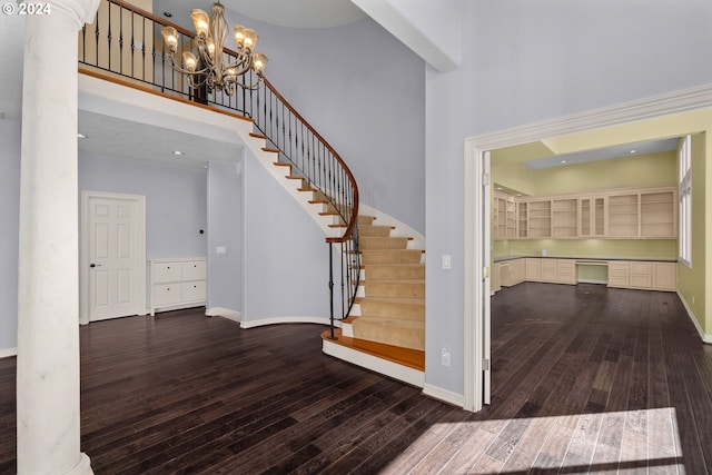 entrance foyer with baseboards, stairs, a high ceiling, and hardwood / wood-style flooring