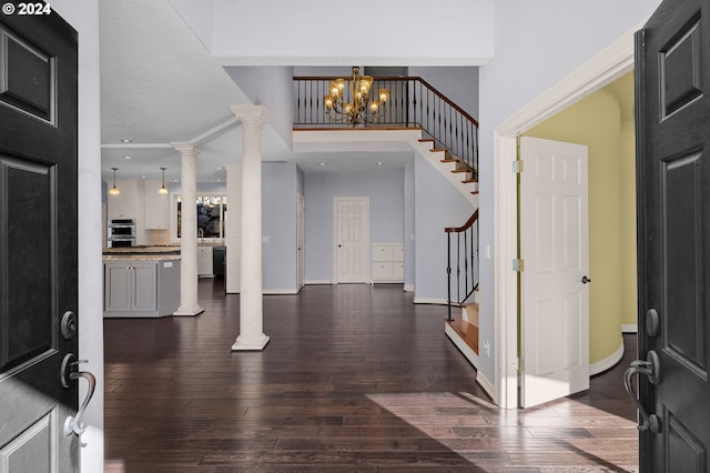 entrance foyer featuring stairs, dark wood-style flooring, baseboards, and a chandelier