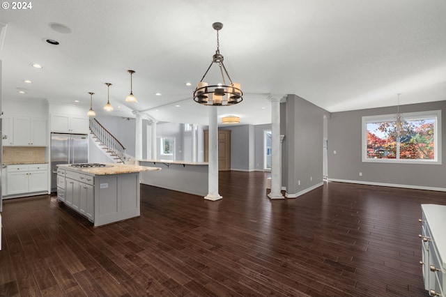 kitchen with open floor plan, decorative columns, and dark wood finished floors
