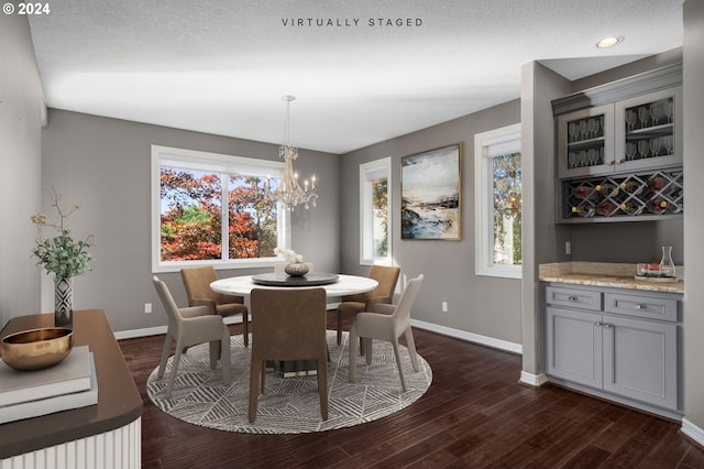 dining room featuring dark wood-style flooring, baseboards, and a notable chandelier