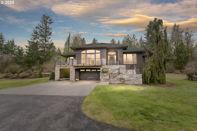 view of front of home with a chimney, concrete driveway, stairway, a front yard, and stone siding