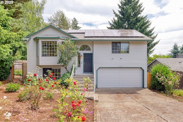 15210 SW 100th Ave, Portland, OR 97224 - bi-level home featuring an attached garage, solar panels, driveway, and roof with shingles