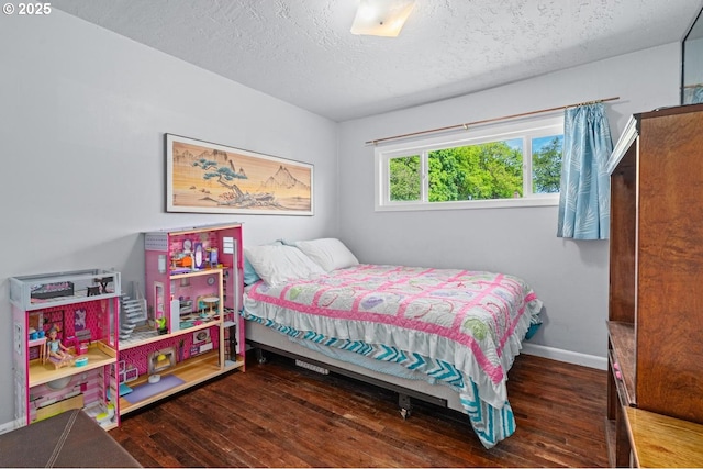 bedroom with baseboards, a textured ceiling, and hardwood / wood-style flooring